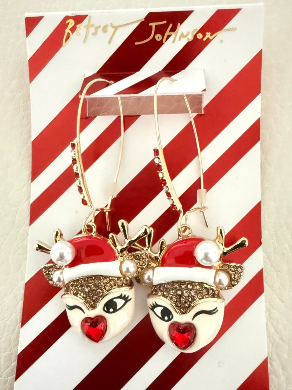 Earring Style: Matching pierced dangle earrings that mirror the winking reindeer